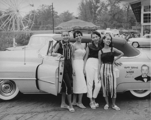 Four young African American women standing beside an automobile 1950