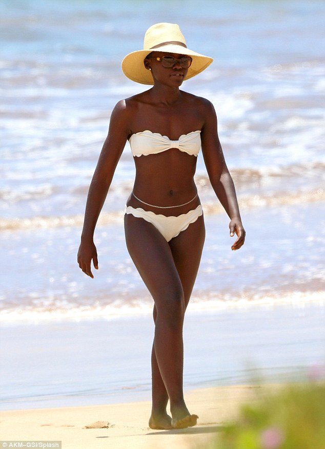 Lupita Nyong'o in a white bikini and straw hat on the beach in Maui 