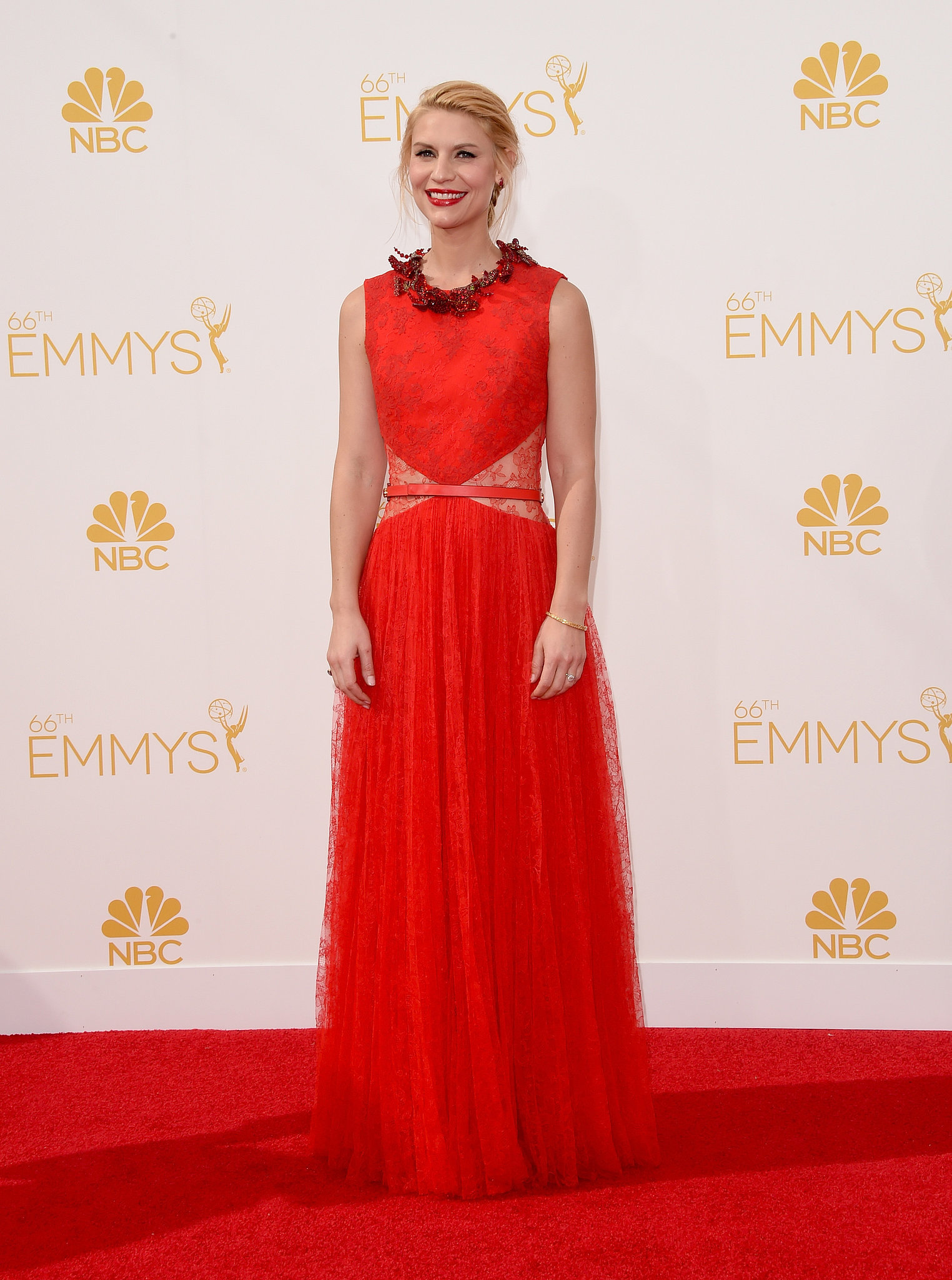 Claire Danes in a red sleeveless Givenchy dress that has lace at the waist , also a skinny belt and jeweled bows at the neckline
