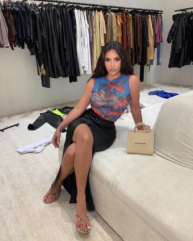 Kim Kardashian wearing flip flops and carrying a black Gucci bag